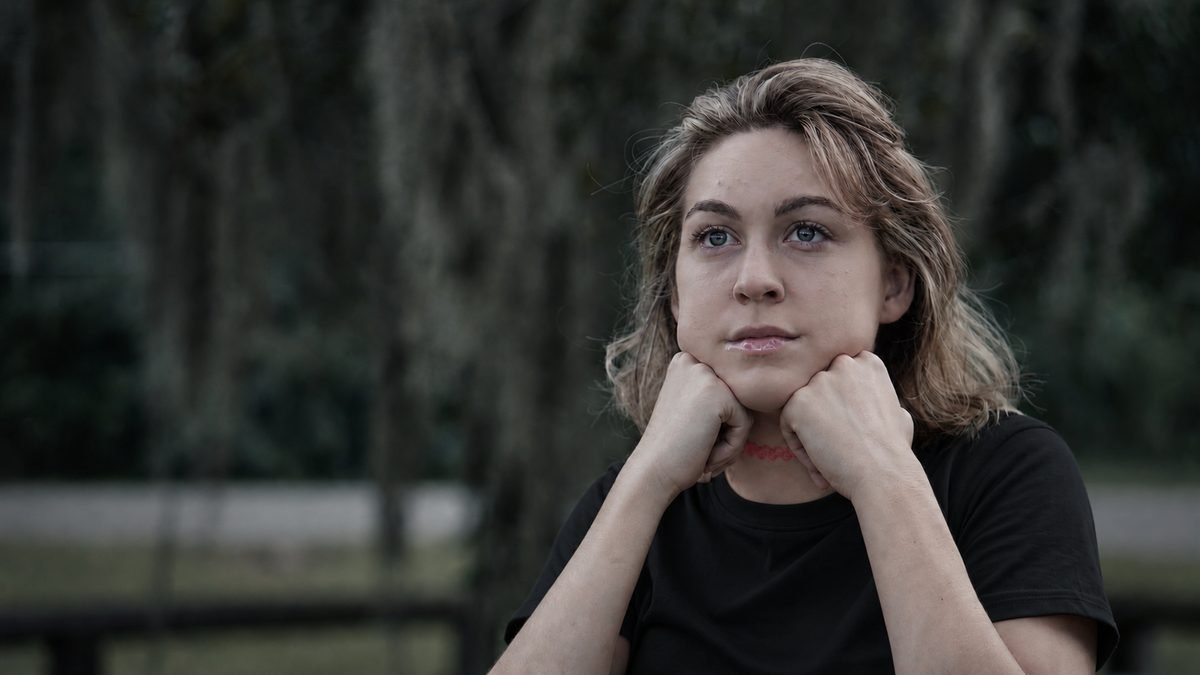 Outdoor portrait of a woman beneath Spanish moss, hands resting beneath her chin